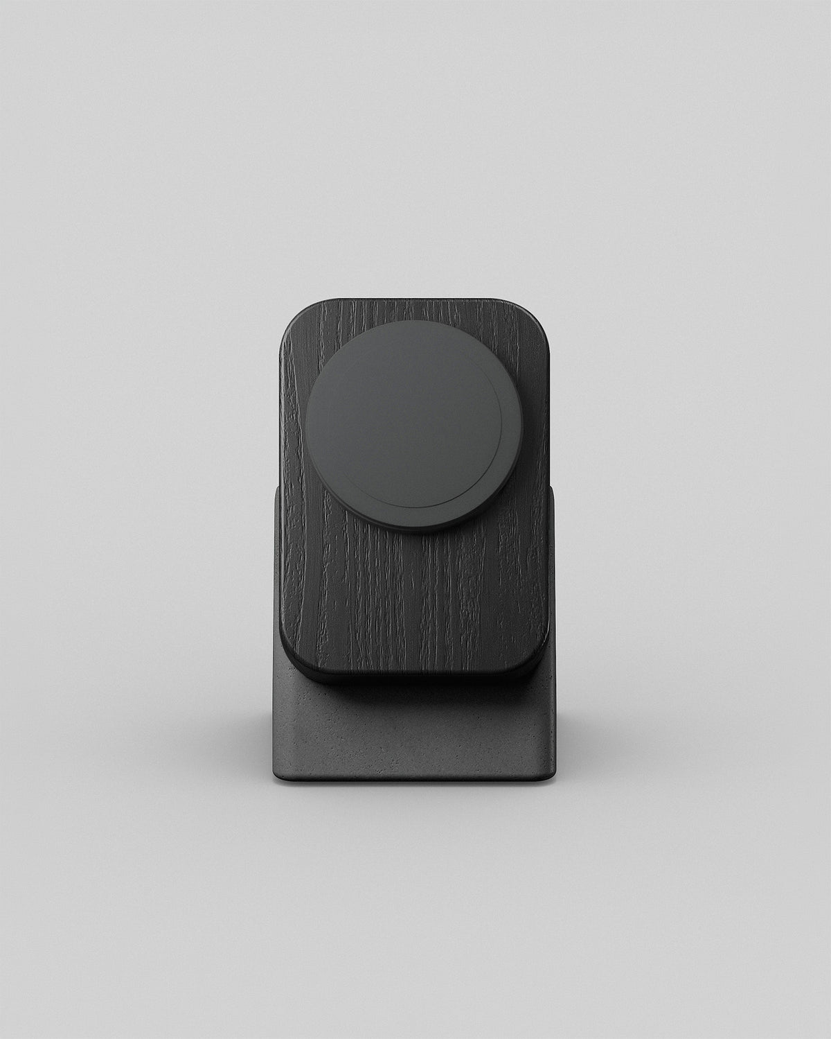 Upright wireless charging stand by Modhaus in black wood and charcoal concrete, front hero view on a light background