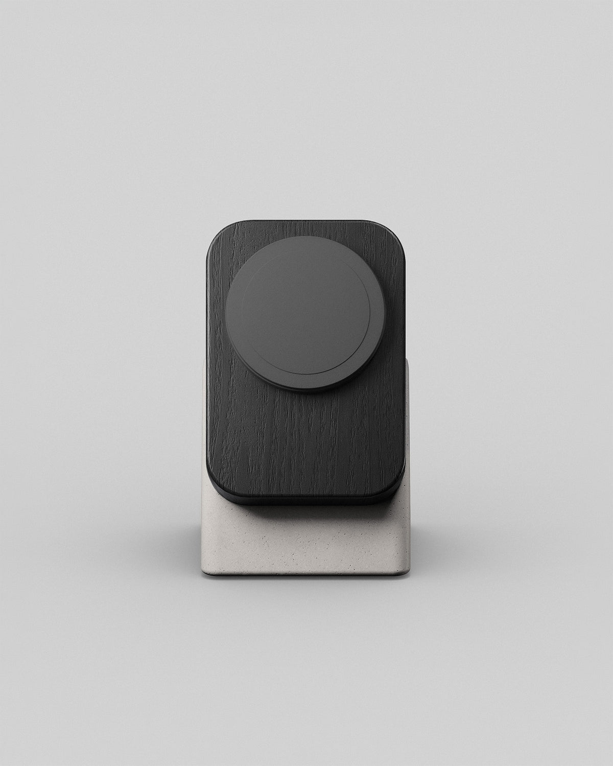 Upright wireless charging stand by Modhaus in black wood and stone concrete, front hero view on a light background