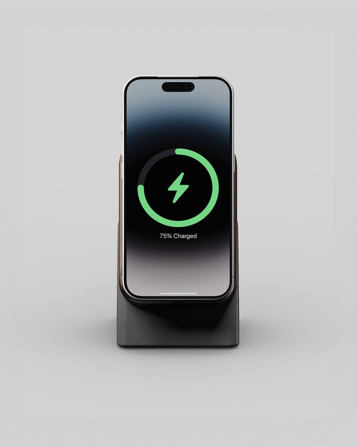 Upright wireless charging stand in walnut and charcoal concrete, front view with a smartphone charging