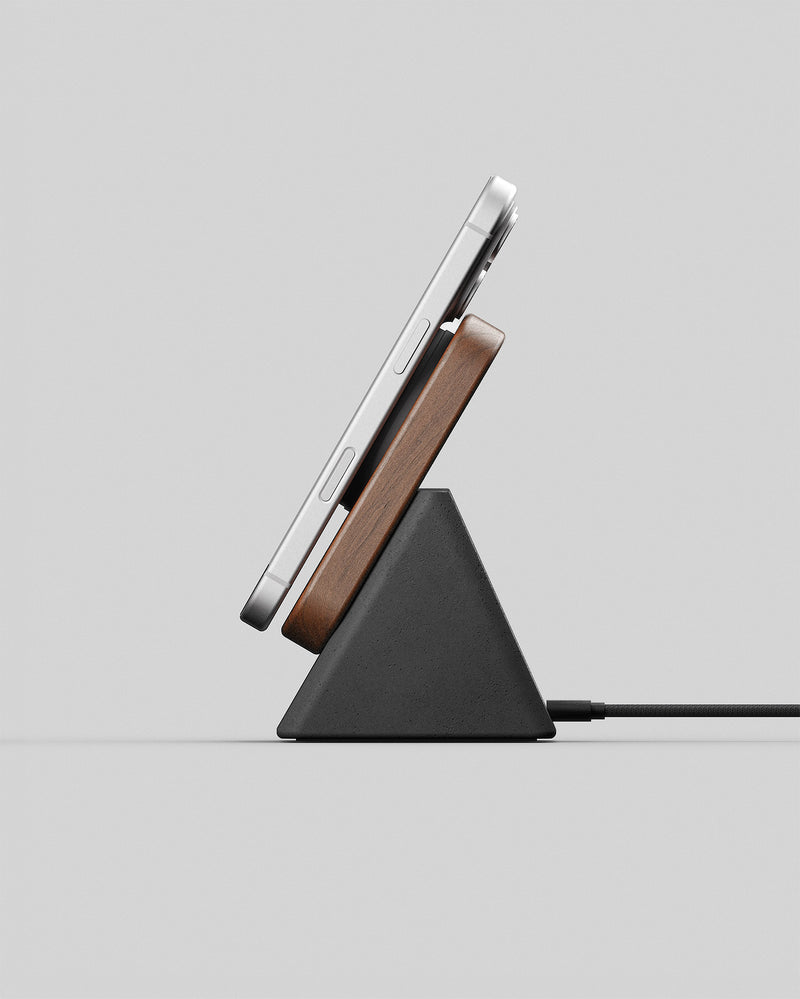 A modern wireless charging stand holding a smartphone against a clean light gray background.