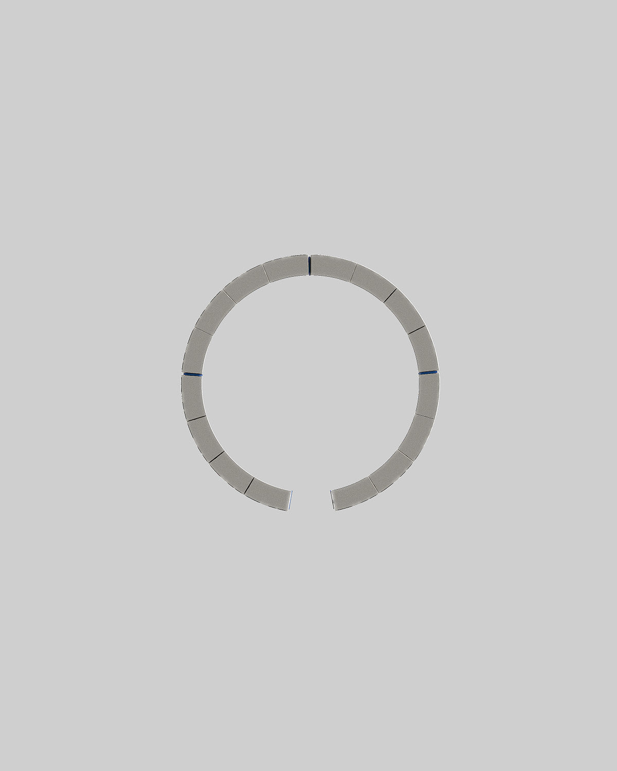 An array of 16 magnets forming a magnetic ring from a MagSafe charger on a light grey background