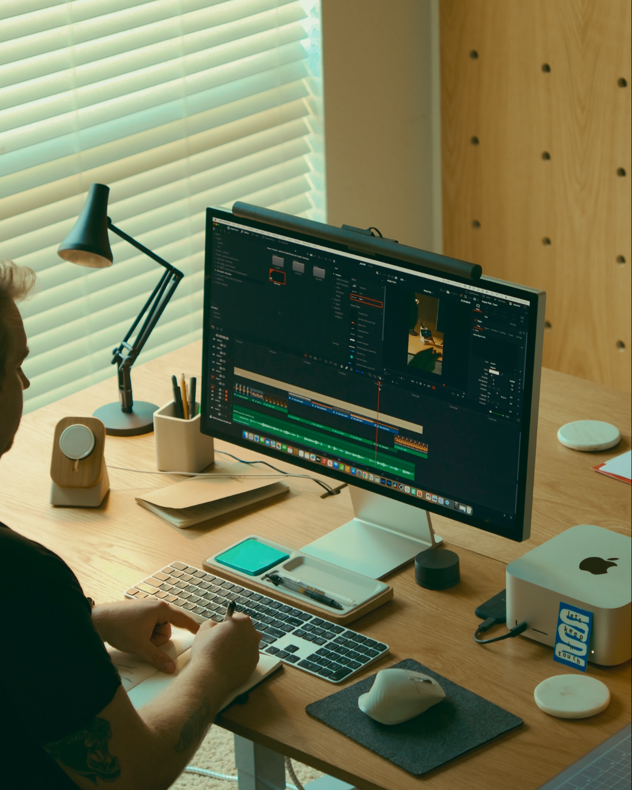 Aaron working at a desk with multiple computer monitors and office supplies.
