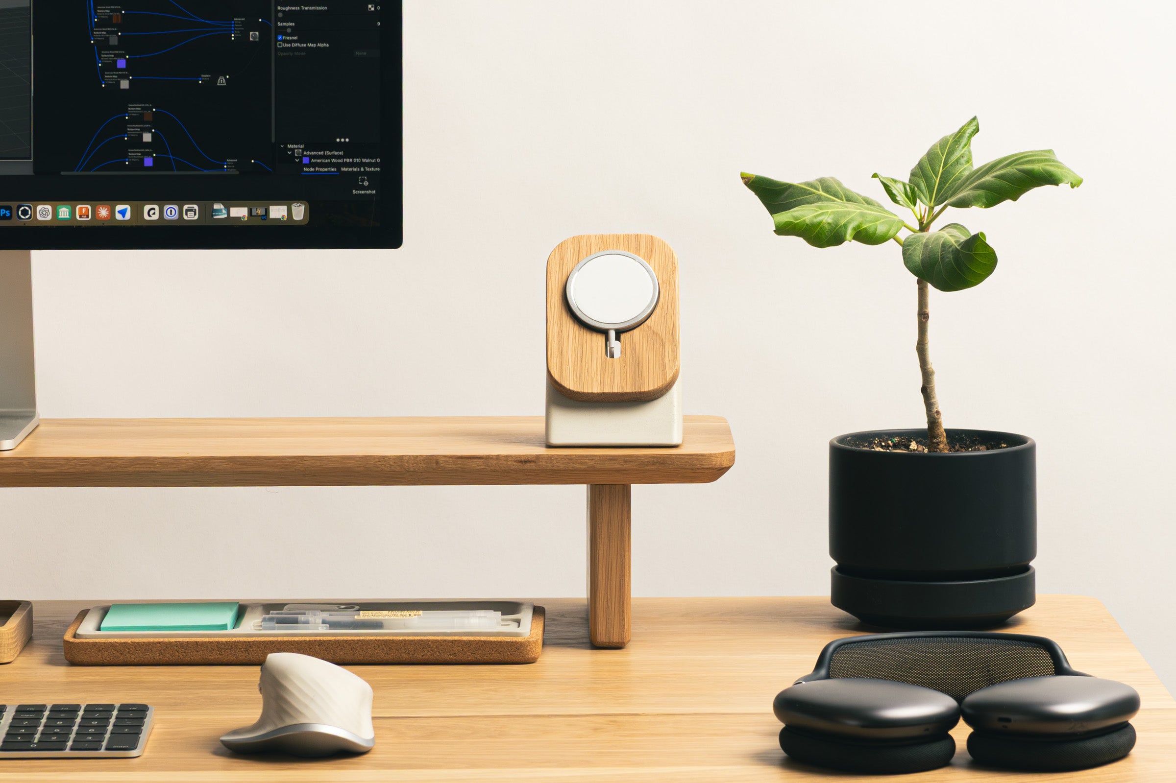Modern office desk setup with computer, plant, and office supplies.