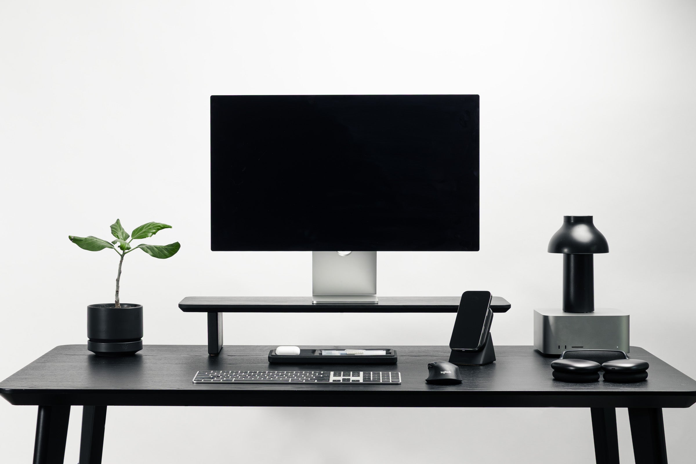 Modern office desk setup with computer monitor, keyboard, and lamp on a white background