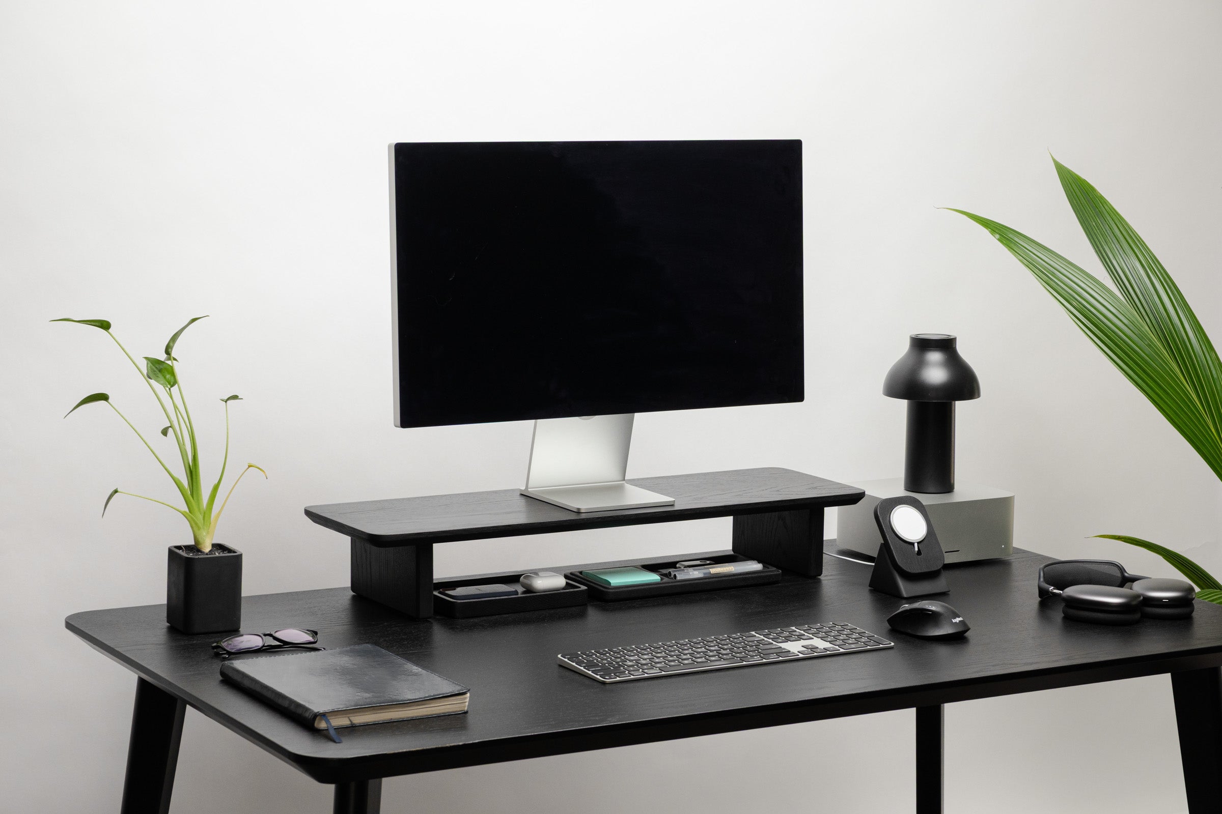 Modern office desk setup with computer monitor, keyboard, mouse, and decorative items.