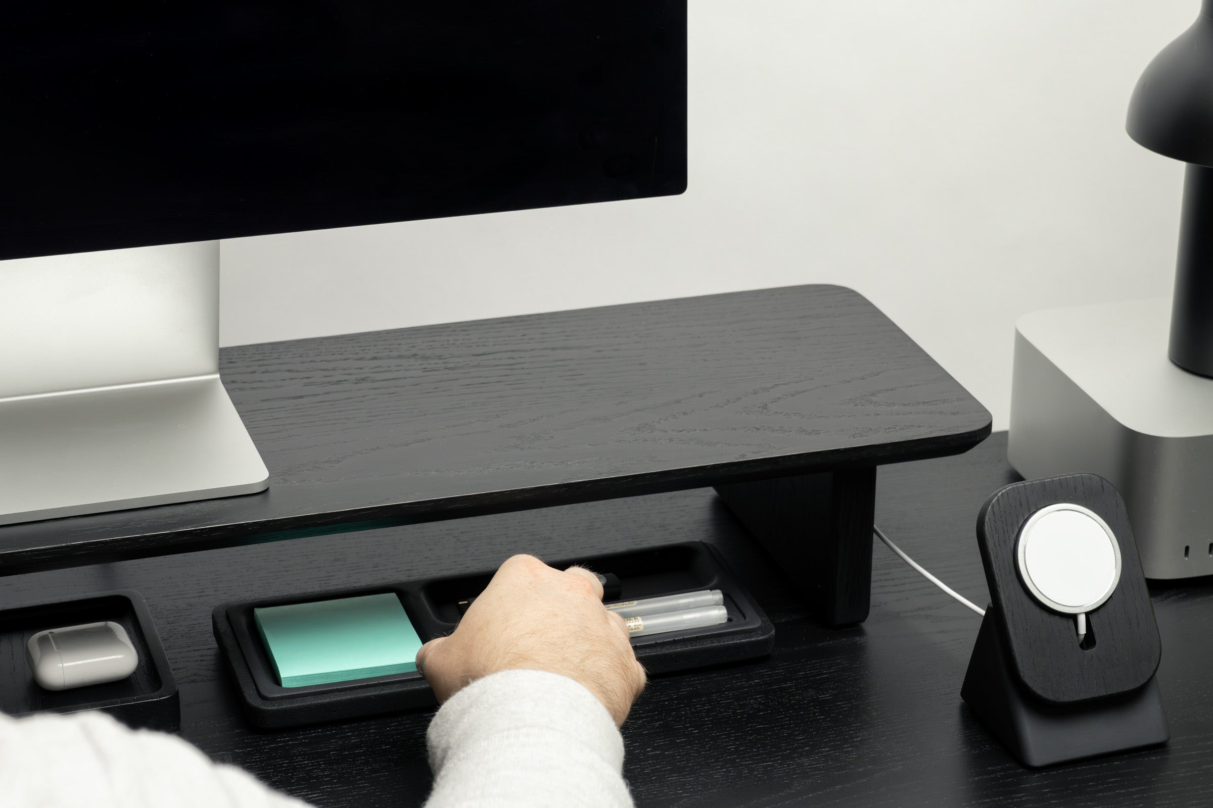Person using a computer monitor stand on a desk with a white background