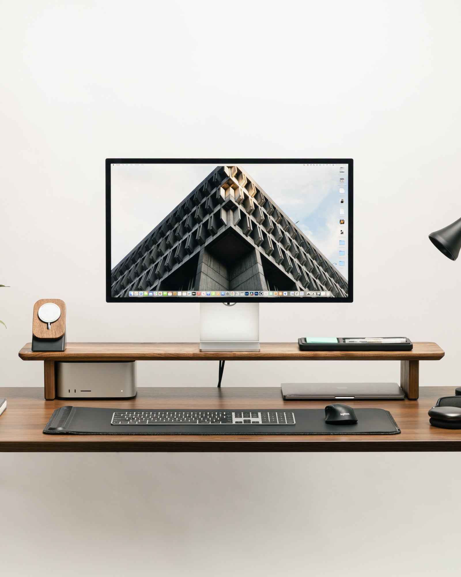 Modern office desk setup with a computer monitor, keyboard, and mouse on a white background