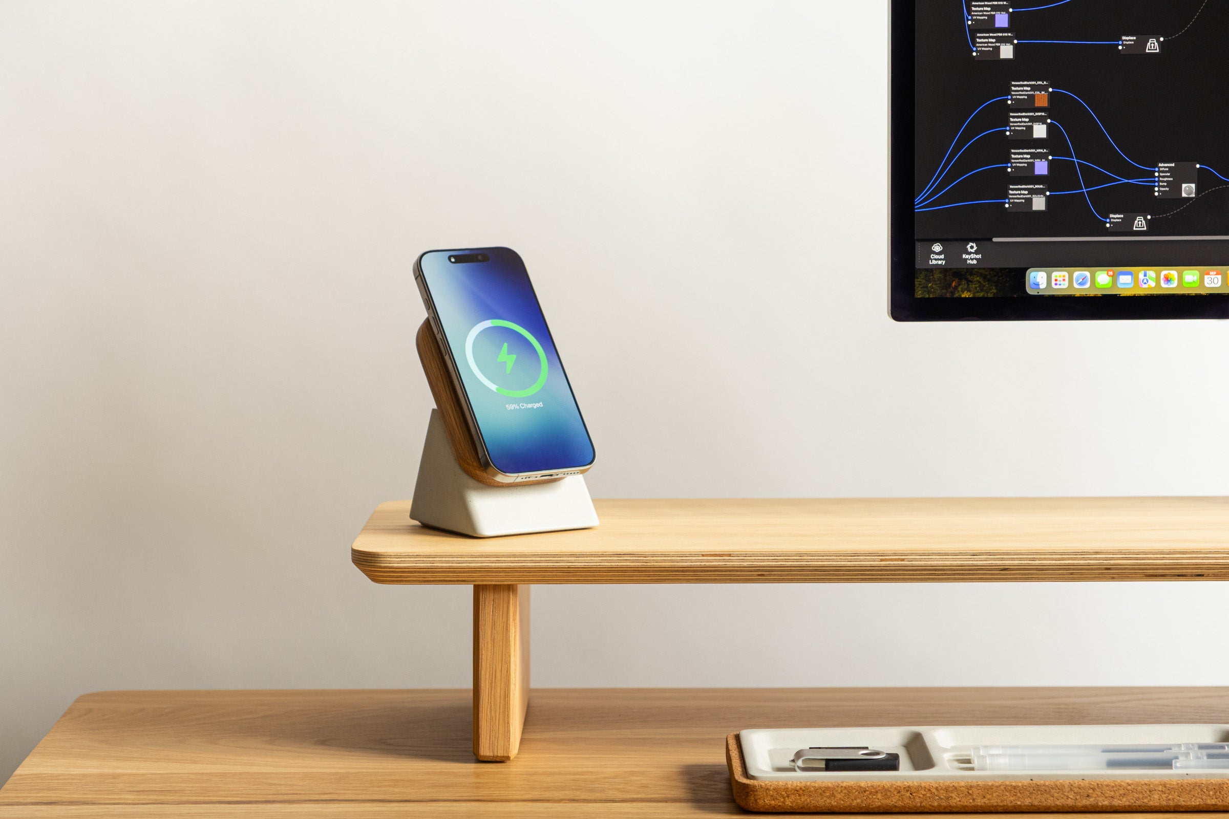 Smartphone on a charging stand with a computer monitor in the background