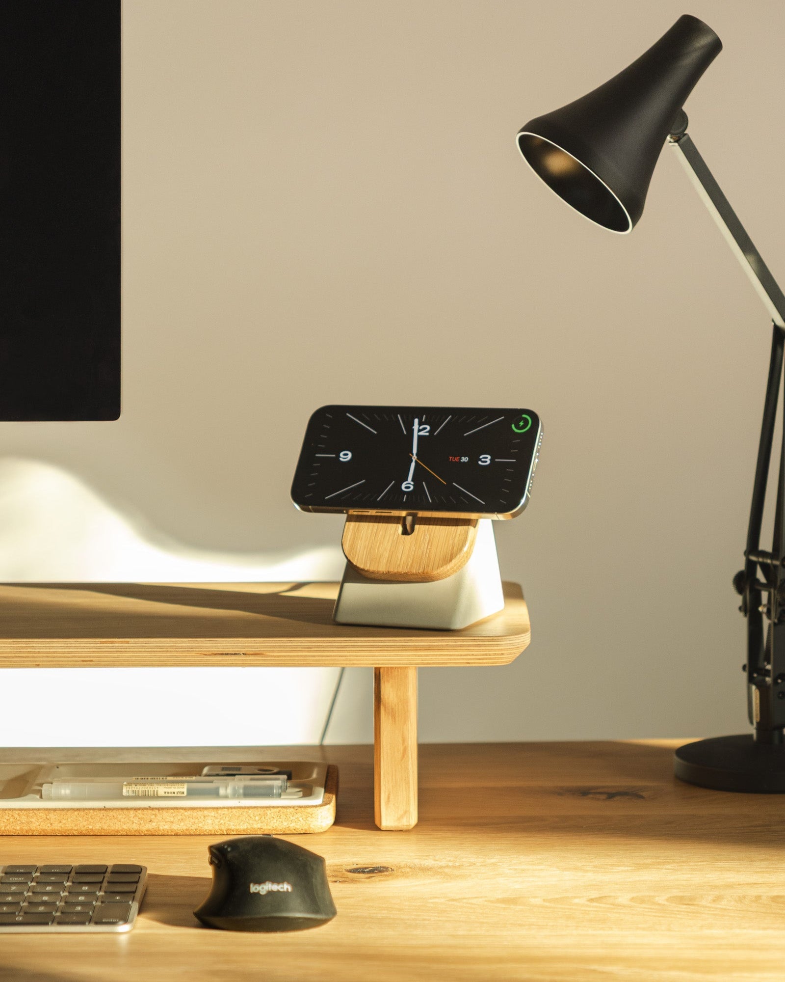 Phone on a stand with a lamp and computer mouse on a desk