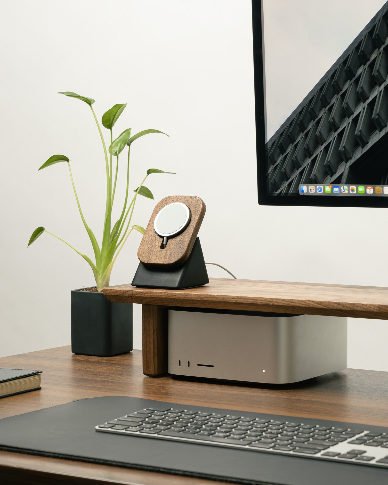 Modern office desk with computer monitor, keyboard, and decorative items.
