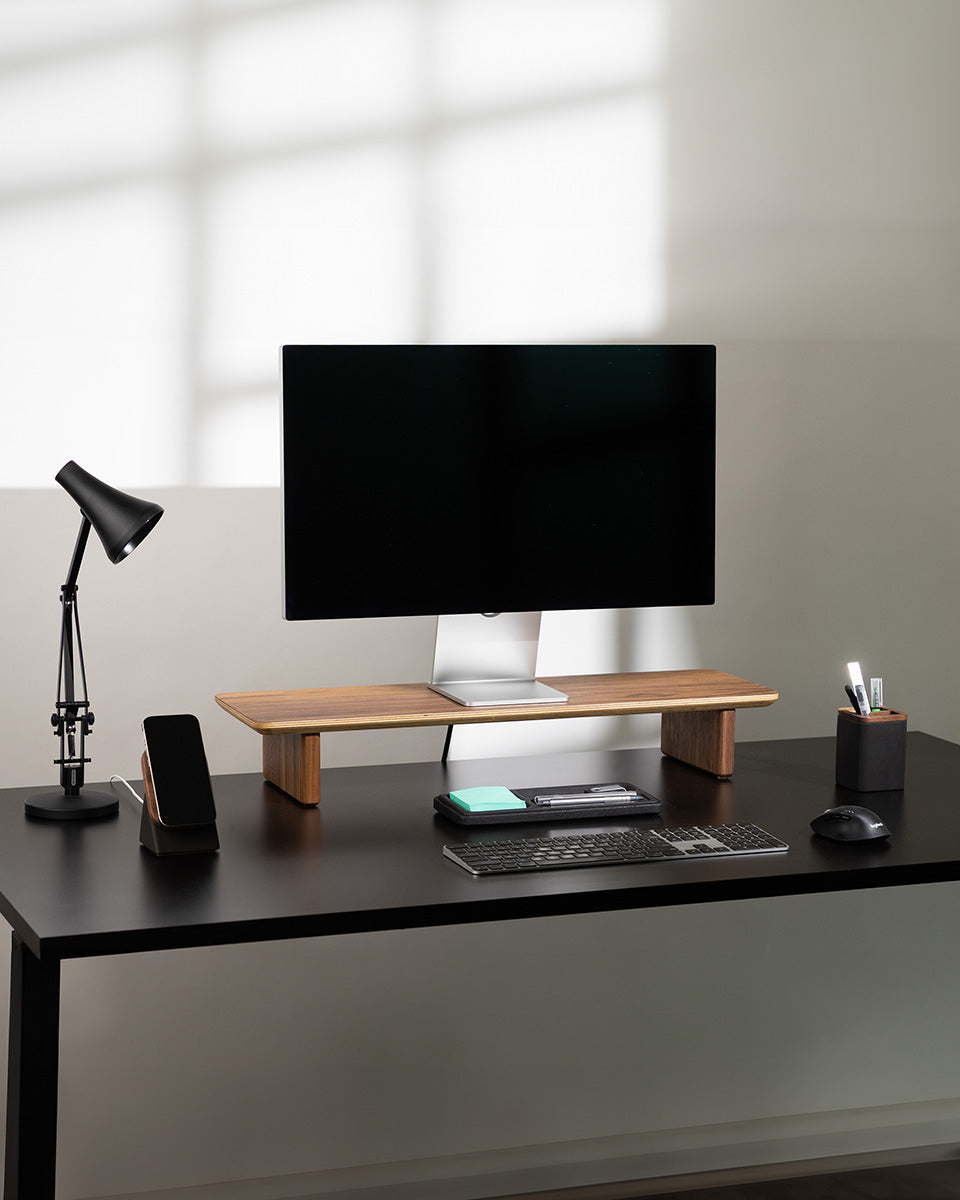 Modern office desk setup with a computer monitor, keyboard, mouse, and office supplies.