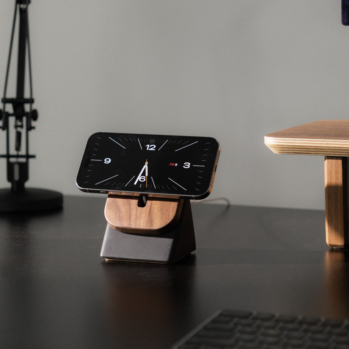 The Modhaus Upright Two MagSafe Stand in Charcoal Concrete and Walnut Wood, showcasing an IPhone in StandBy Mode