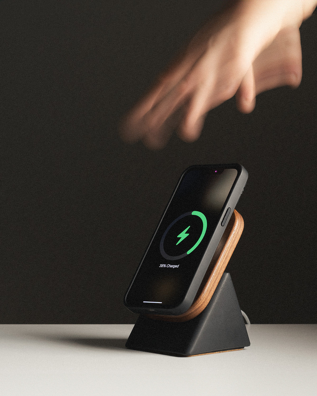 Wireless charging stand with a smartphone on a dark background