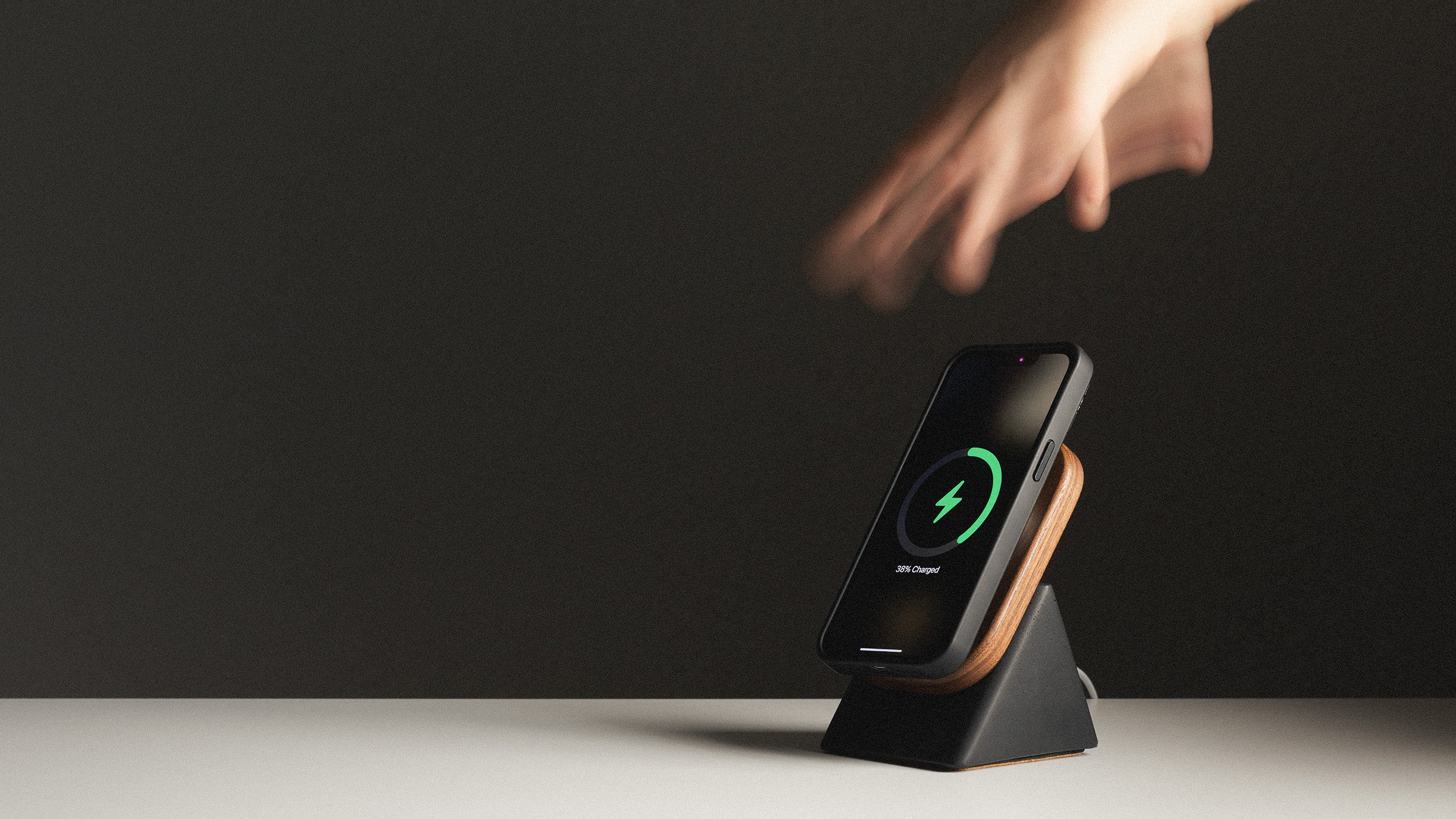 Wireless charging stand with a smartphone on a dark background