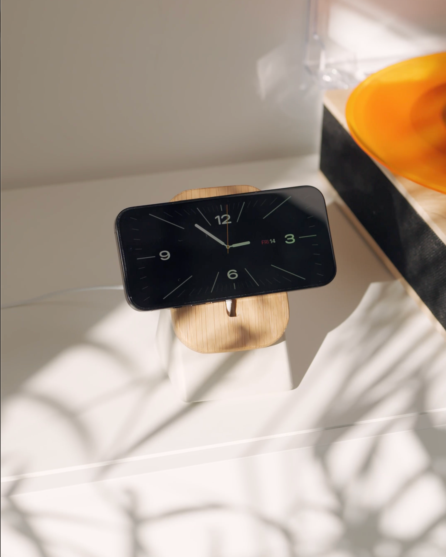 Apple iPhone in StandBy Mode on the Modhaus Upright Magsafe stand in Oak