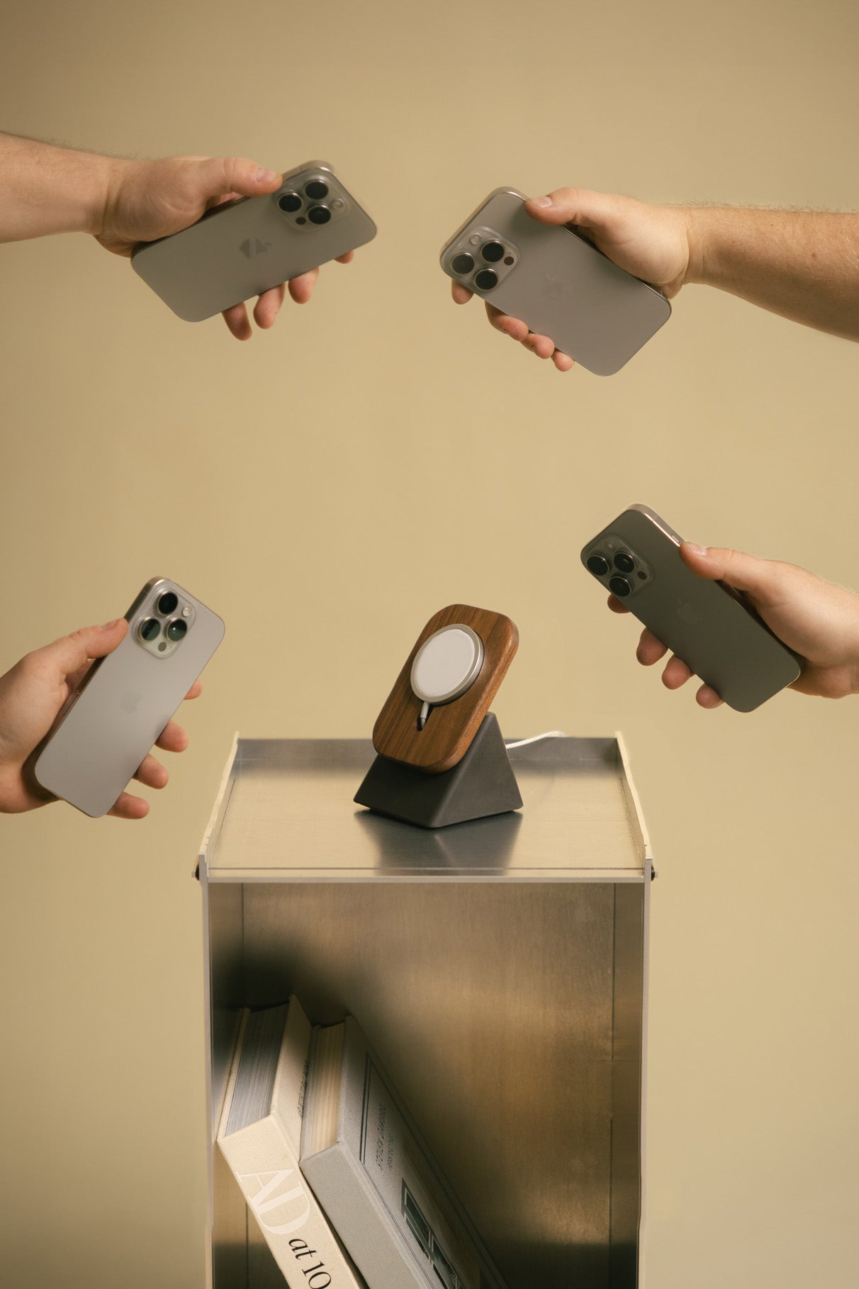 Multiple hands reaching for the Upright Two in Walnut / Charcoal